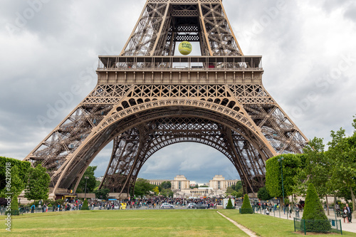 Tourists near Eiffel Tower with big tennis ball of Roland Garros in Paris, France © Kruwt