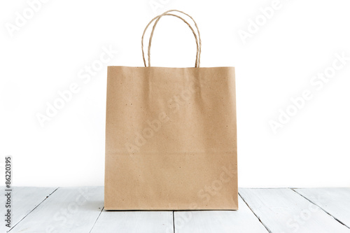 Paper bag on the wooden background photo