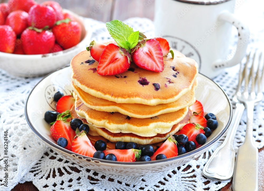 Blueberry Pancake with strawberries and a cup of milk on a wooden table Blueberry Pancake with strawberries and a cup of milk on a wooden table