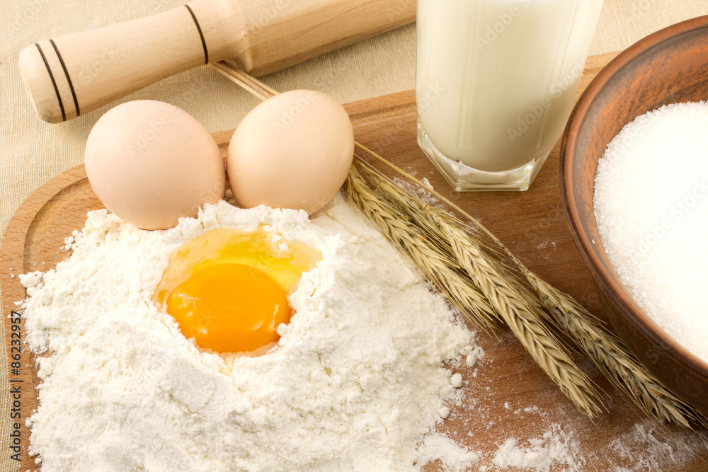 Still life of bread, eggs, cereals, flour and kitchen tools on a wooden board Still life of bread, eggs, cereals, flour and kitchen tools on a wooden board