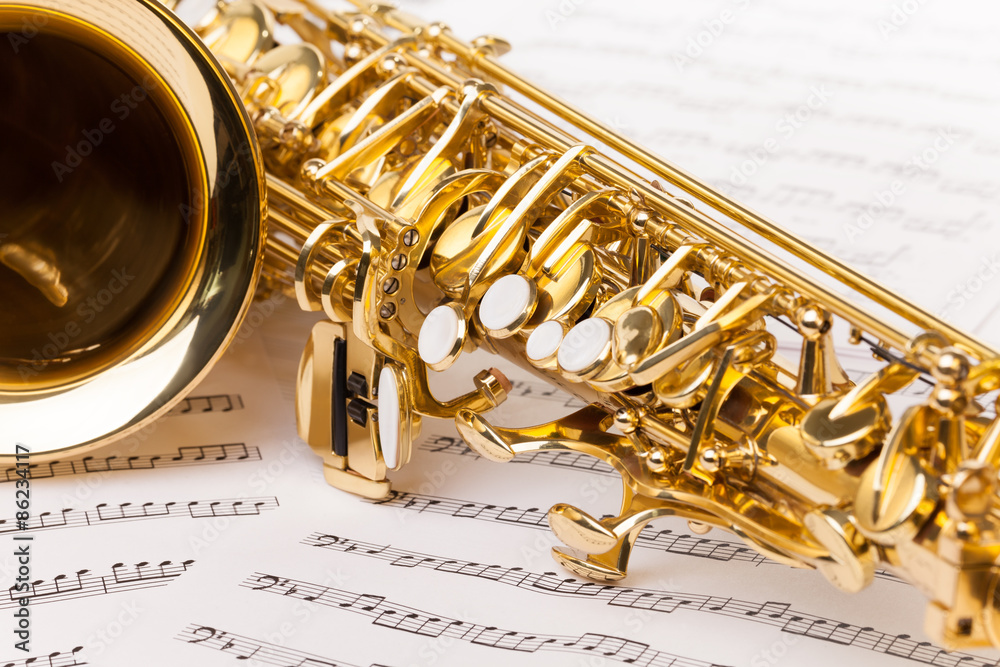 Obraz premium Beautiful golden alto saxophone on musical notes 