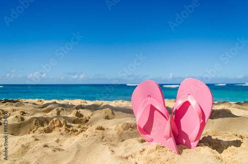 Pink flip flops on the sandy beach