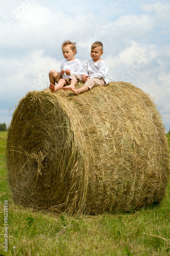 two happy boys on hay bales