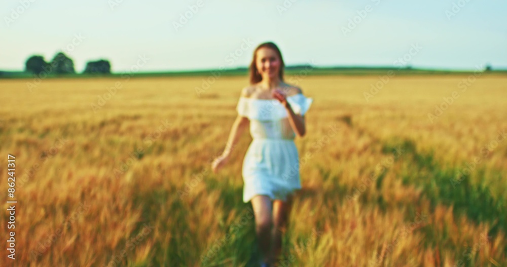 Beautiful girl running on sunlit wheat field. Slow motion 120 fps. Sun lens flare. Freedom concept. Happy woman having fun outdoors in a wheat field on sunset or sunrise. Slow motion. Harvest. Beautiful girl running on sunlit wheat field. Slow motion 120 fps. Sun lens flare. Freedom concept. Happy woman having fun outdoors in a wheat field on sunset or sunrise. Slow motion. Harvest.