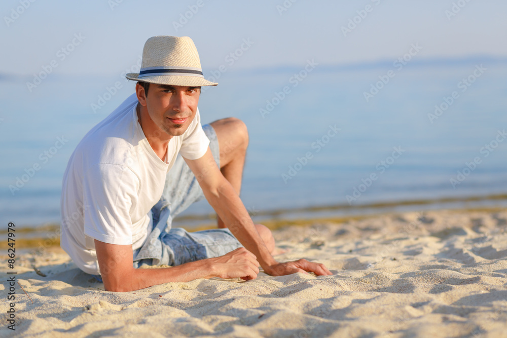 Young man with a hat  relaxing on the beach