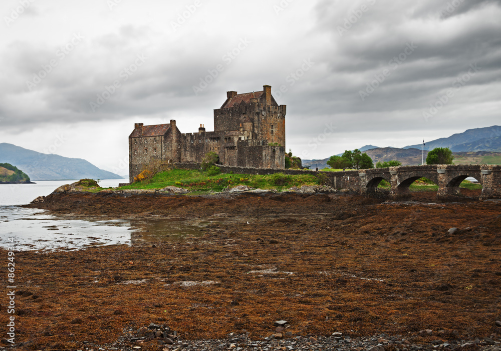 Eilean Donan castle on a cloudy day. low tide. Highlands, Scotland. UK