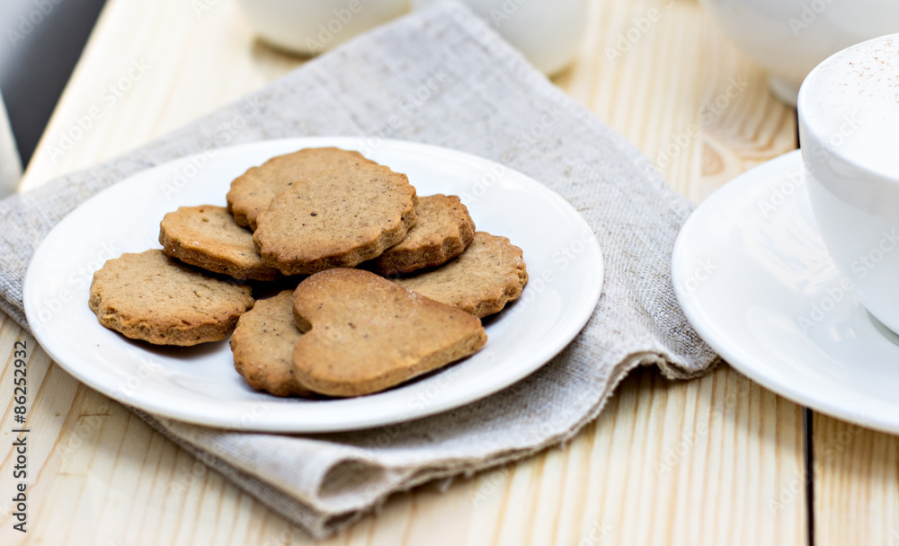 Ginger biscuits, cinnamon, a cup of hot coffee. Walnuts, hazelnuts on a wooden background Ginger biscuits, cinnamon, a cup of hot coffee. Walnuts, hazelnuts on a wooden background