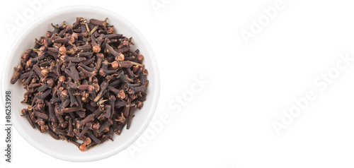 Clove spices in white bowl over white background