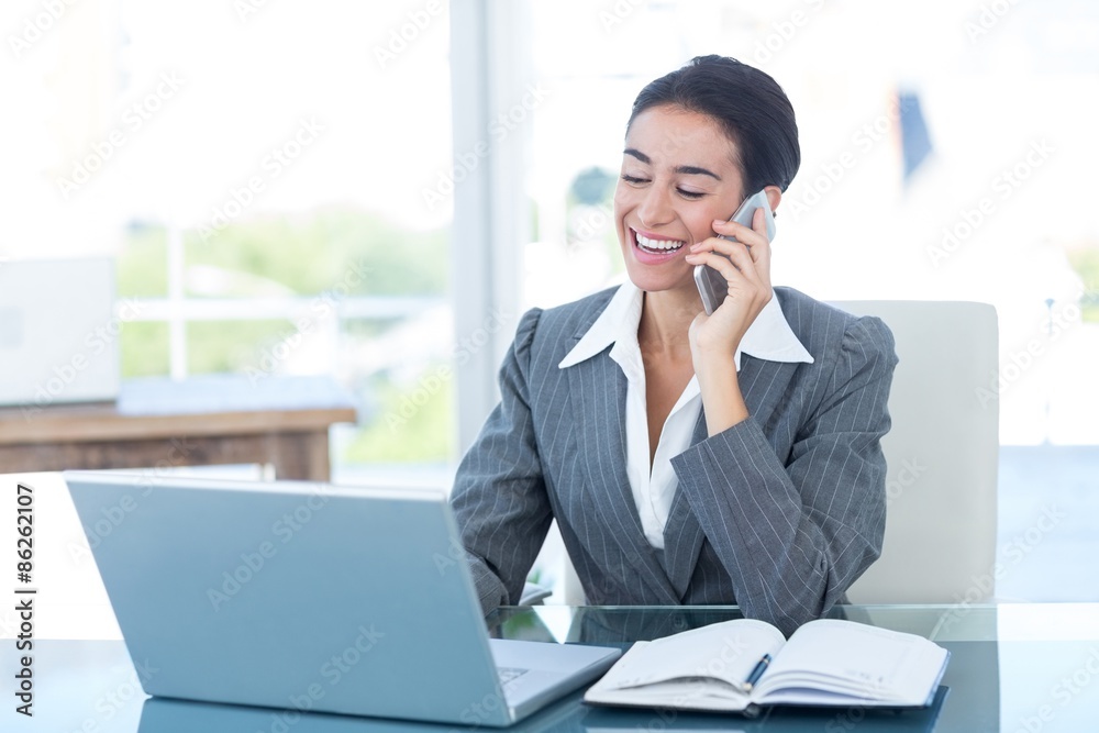 Businesswoman on call and using her laptop Businesswoman on call and using her laptop
