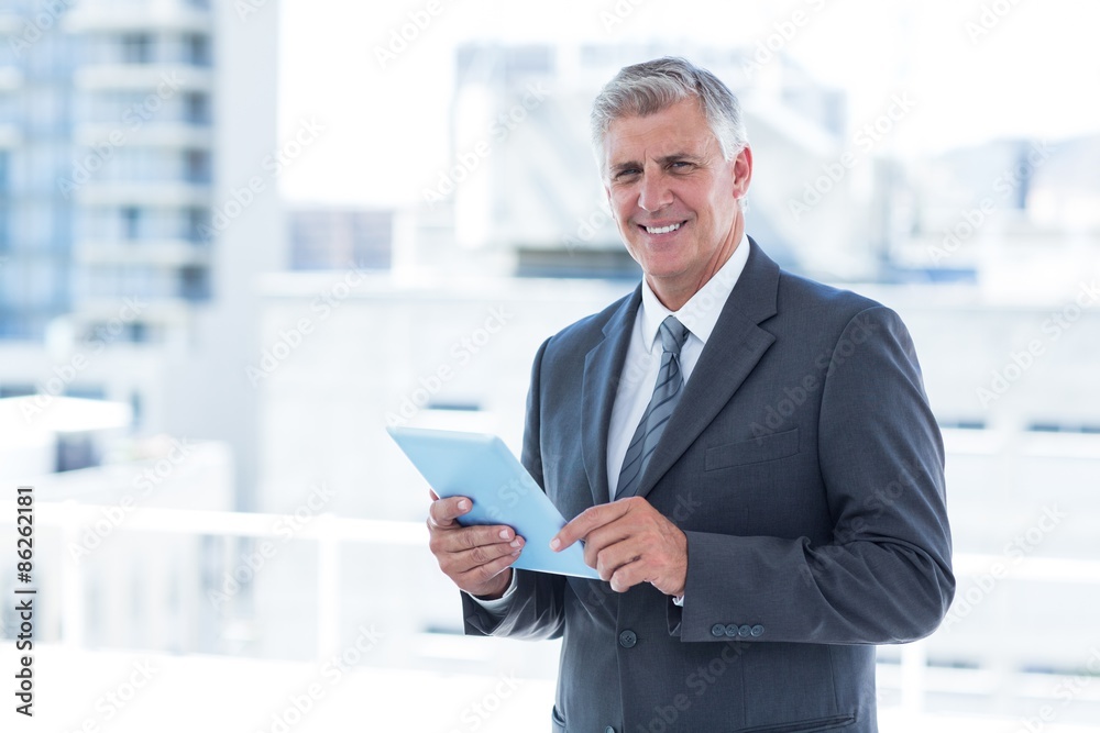 Smiling businessman using his tablet Smiling businessman using his tablet