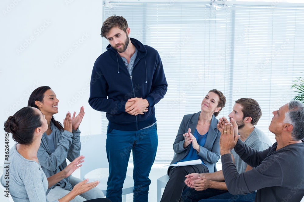 Rehab group applauding delighted man standing up Rehab group applauding delighted man standing up