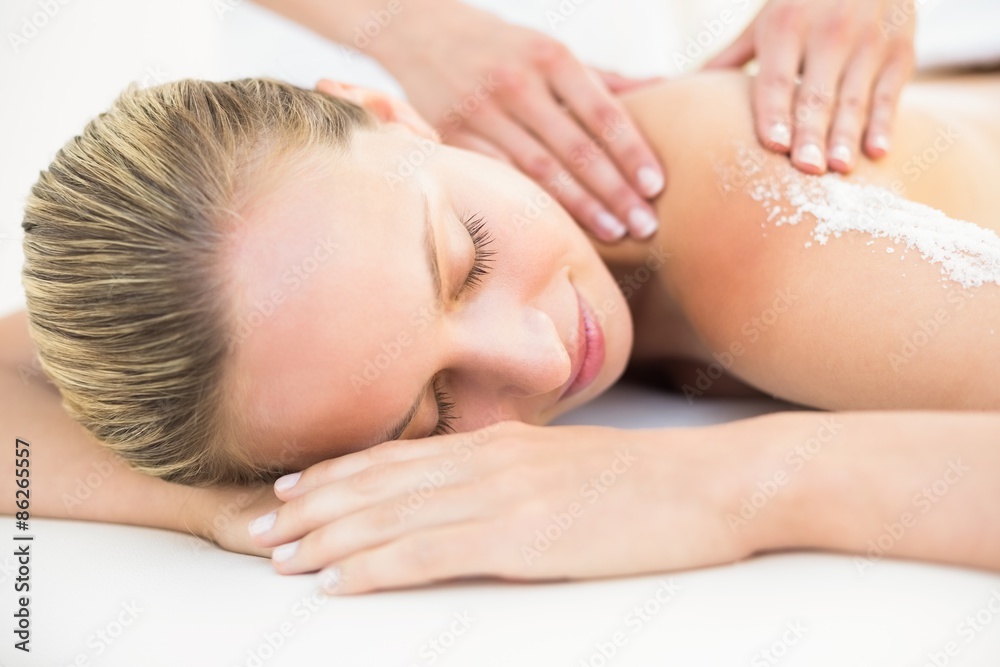 Beautiful woman receiving stone massage at spa center