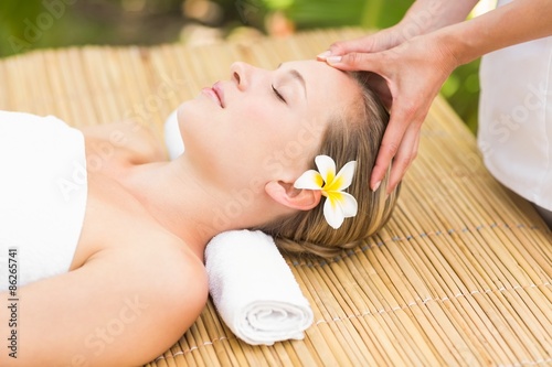 Attractive young woman receiving facial massage at spa center