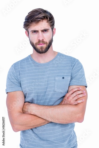 Unhappy handsome man looking at camera with arms crossed 