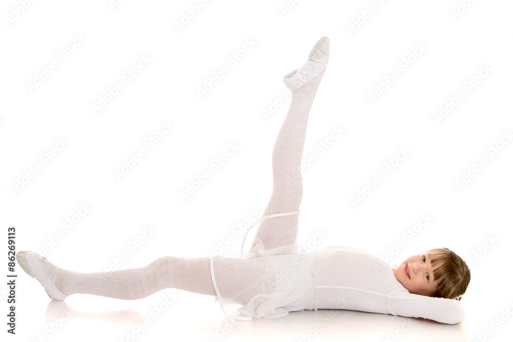 Girl gymnast in white swimsuit does sports exercise lying on the Girl gymnast in white swimsuit does sports exercise lying on the