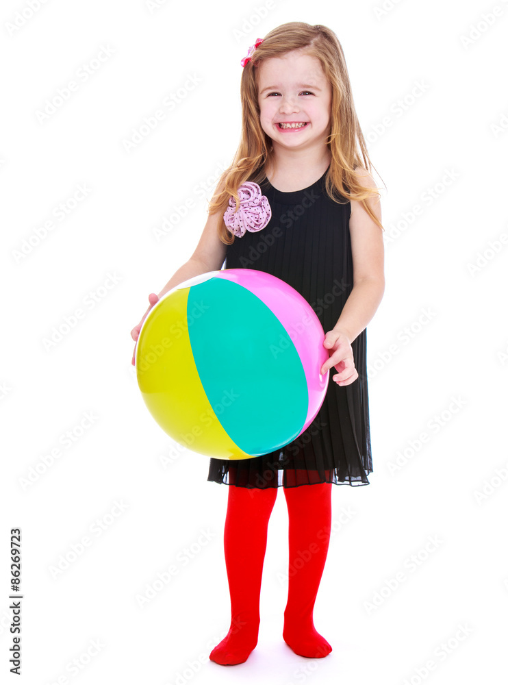 Stylish little blonde, long-haired girl in a fashionable black d
