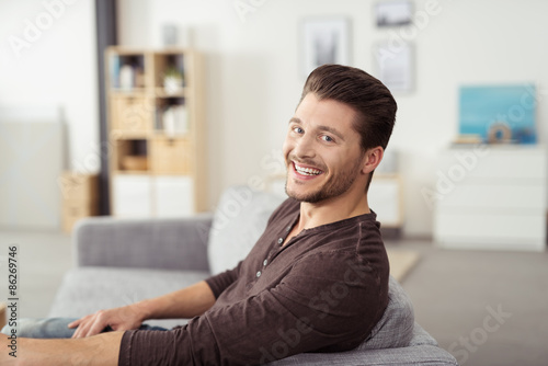 lachender mann zu hause auf dem sofa