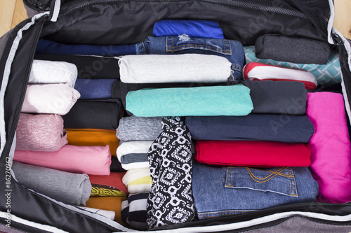 Open suitcase with clothing in the room