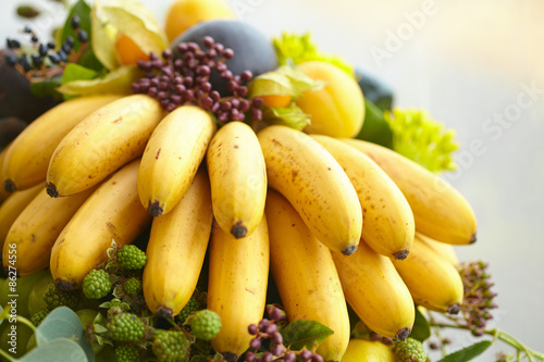 Fruit basket close-up: bananas, apples, grapes, apricots