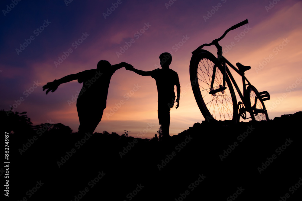 Wide moving silhouettes of two boys holding hands