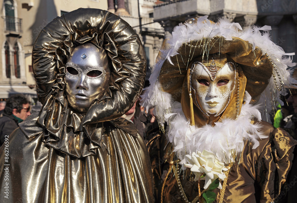 masked persons in golden costume on San Marco Square in Venice,
