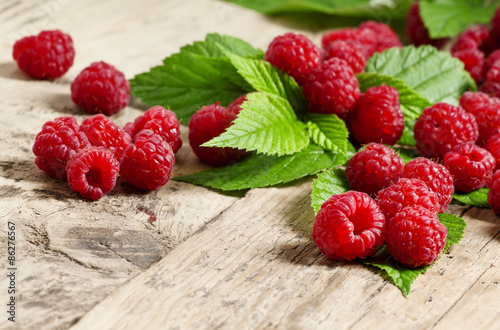 Wallpaper Mural Fresh ripe raspberries with large leaves on the old wooden table