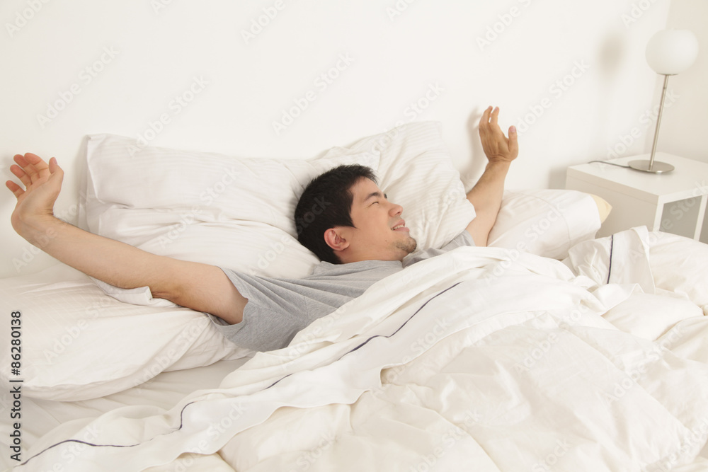 Man stretching in his bed Man stretching in his bed