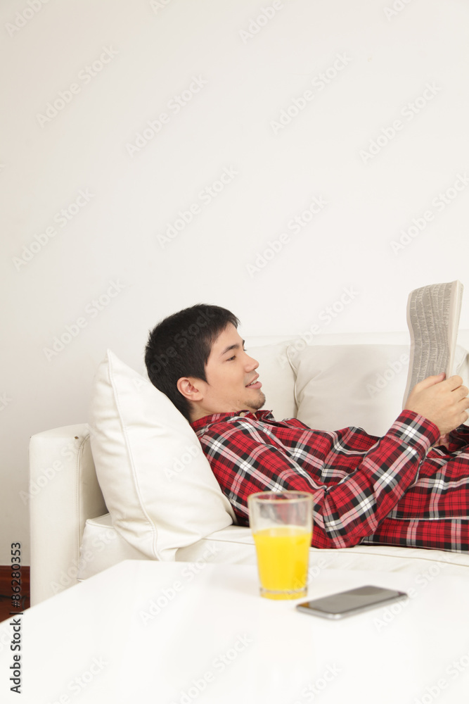 Man reading the newspaper and drinking a juice Man reading the newspaper and drinking a juice