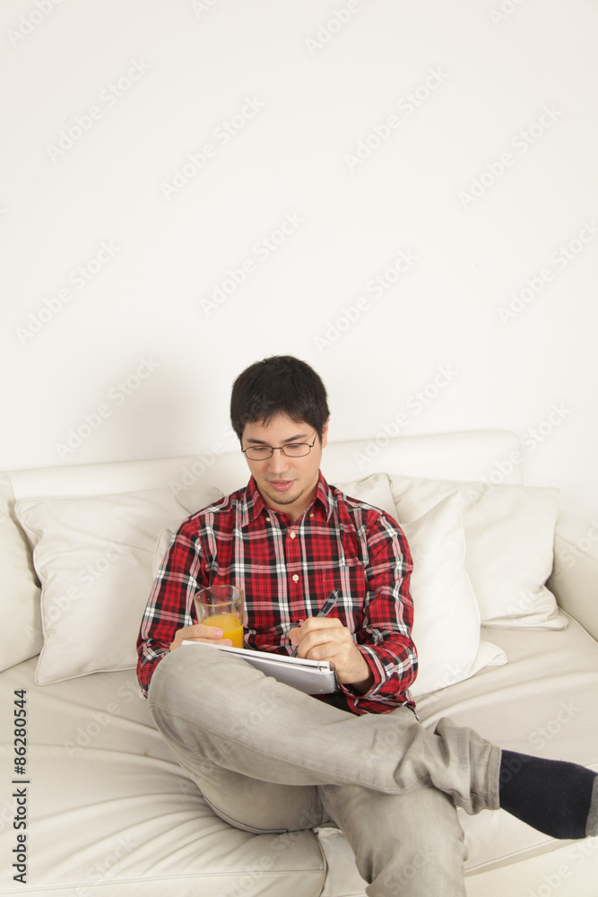 Man writing and drinking a juice