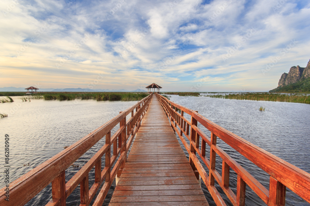 Obraz premium Wooden Bridge in lotus lake on sunset time at Khao Sam Roi Yot National Park, Thailand