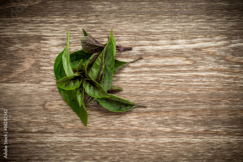Leaves of basil on a old wooden table