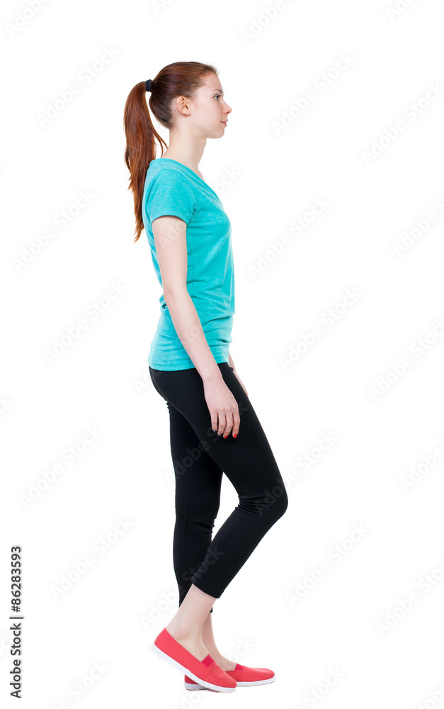 side view of walking  woman in sports tights.