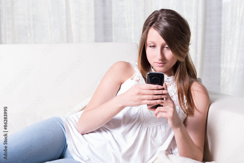 attractive young girl reading a message on smartphone attractive young girl reading a message on smartphone