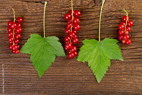 Canvas Print redcurrant berries and leaves over old wooden background