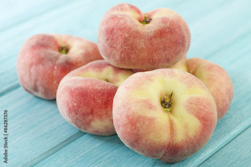 Saturn Peach - Doughnut peaches on a blue background.
