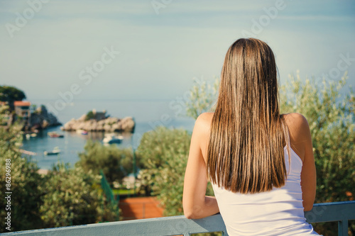 Beautiful young woman looking at the sea. Montenegro, Europe. Toning image.
