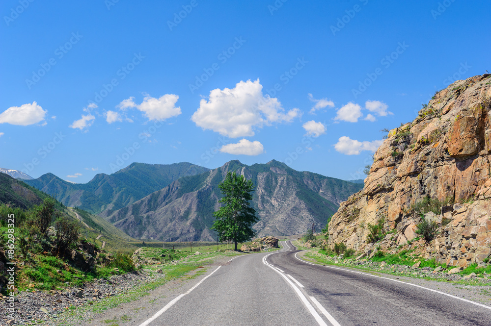 Road passing through mountain valley in Altai in summer