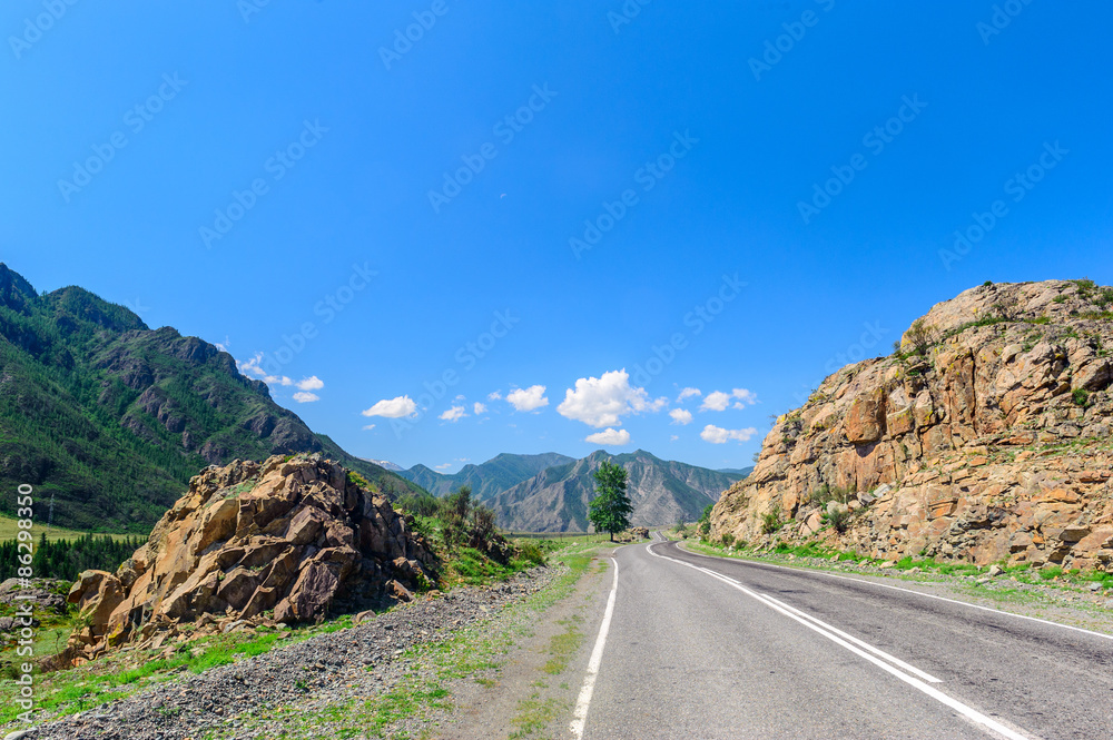 Road passing through mountain valley in Altai in summer