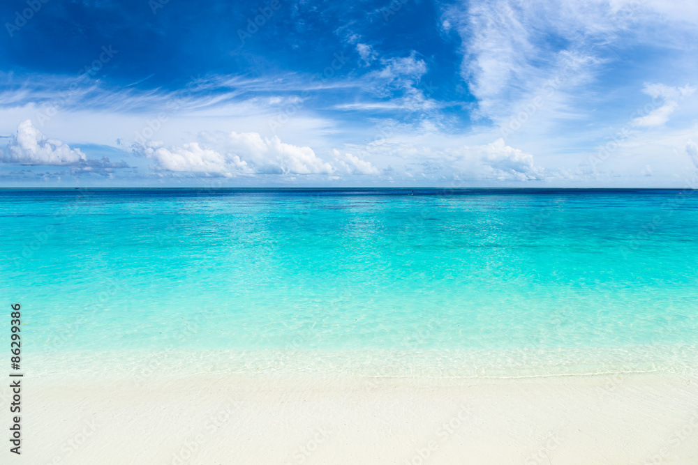 tropical paradise beach with crystal clear, turquoise blue water, wonderful clouds and sky