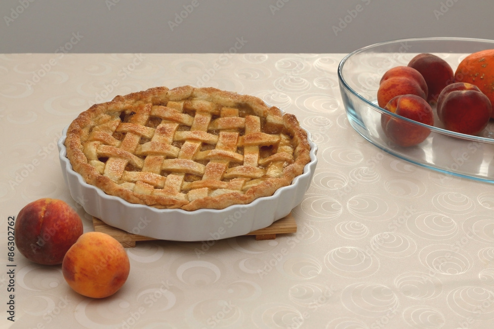 Peach pie and fresh peaches on the table. Selective focus. Peach pie and fresh peaches on the table. Selective focus.