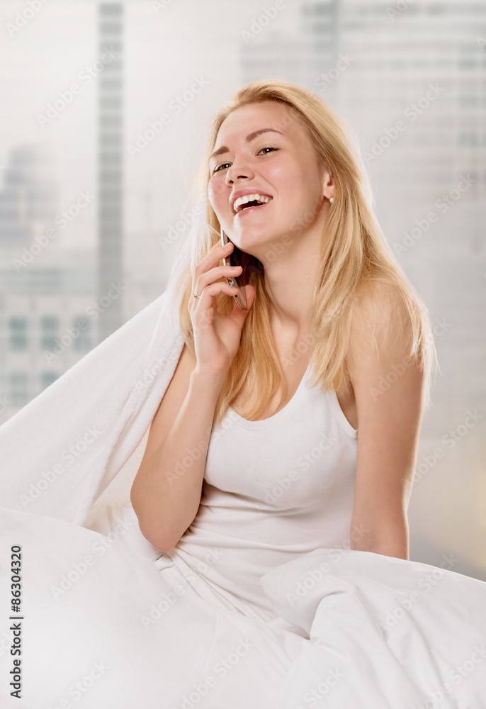 Radiant woman with phone on her bed Radiant woman with phone on her bed
