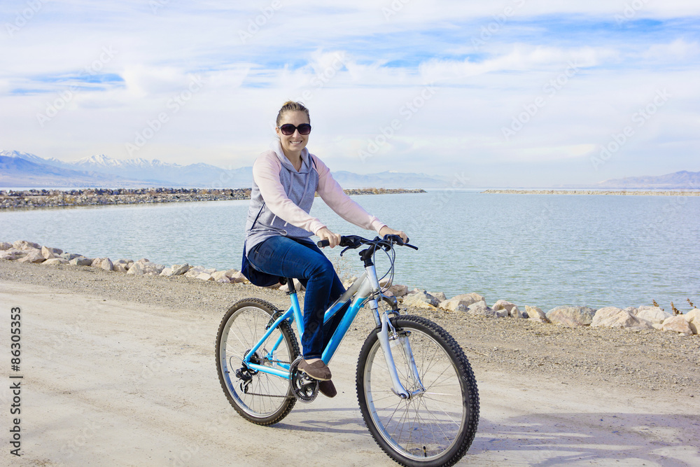 Healthy woman biking along the waterfront