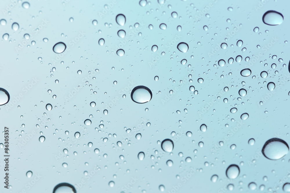Water drop on sky glass mirror background.