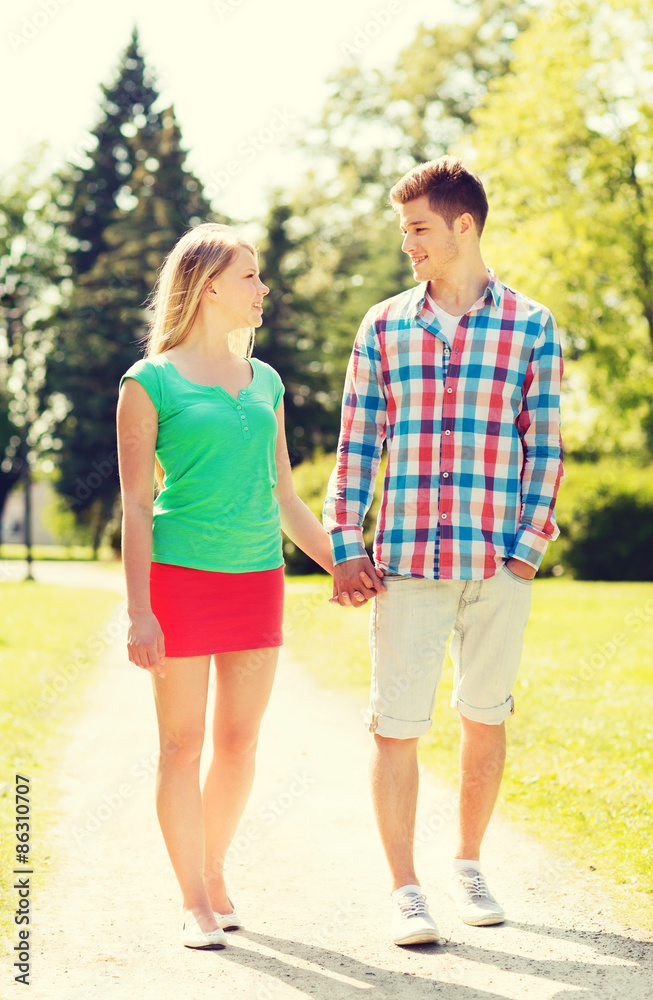 smiling couple walking in park smiling couple walking in park