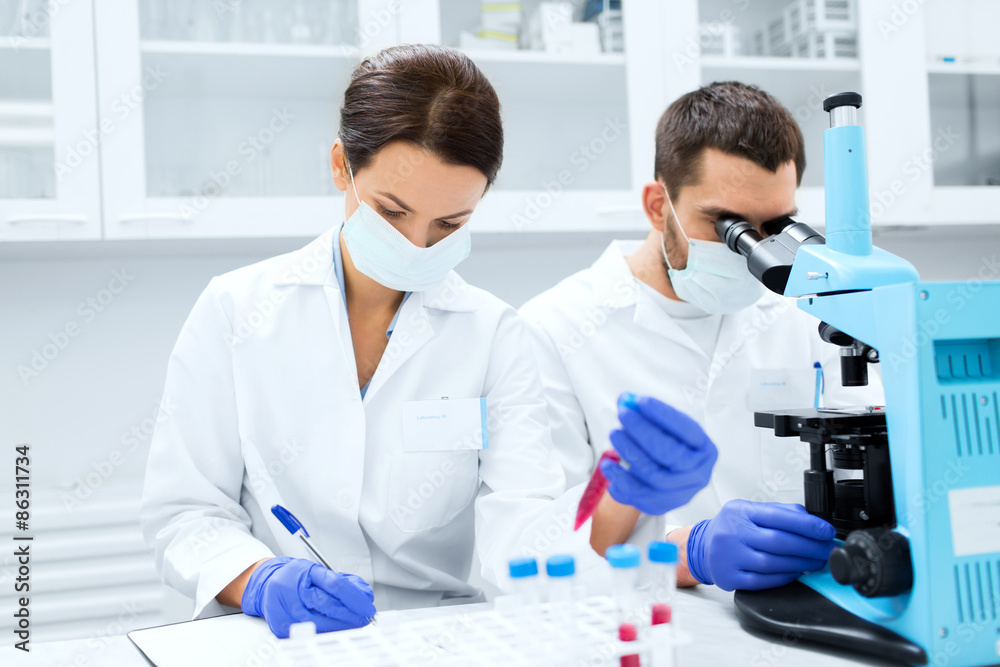 scientists with clipboard and microscope in lab scientists with clipboard and microscope in lab