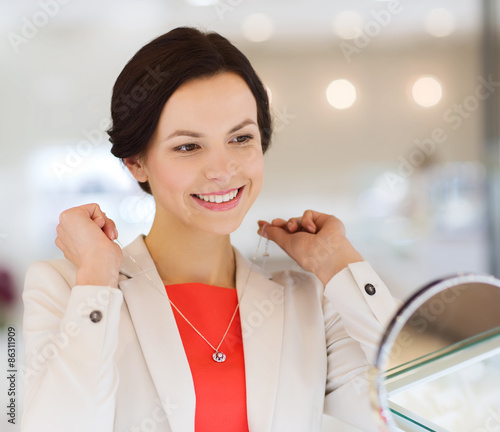Photos happy woman choosing pendant at jewelry store