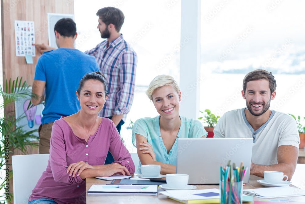 Creative colleagues using laptop in meeting Creative colleagues using laptop in meeting