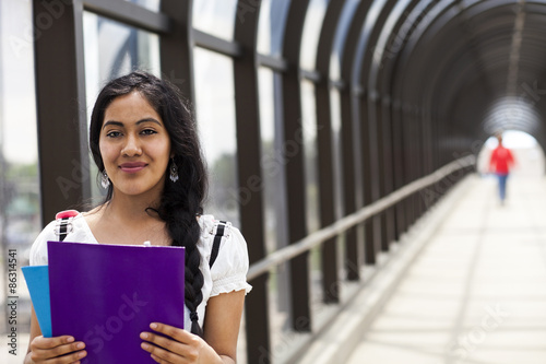 University / college student girl looking happy smiling with book on the bridge