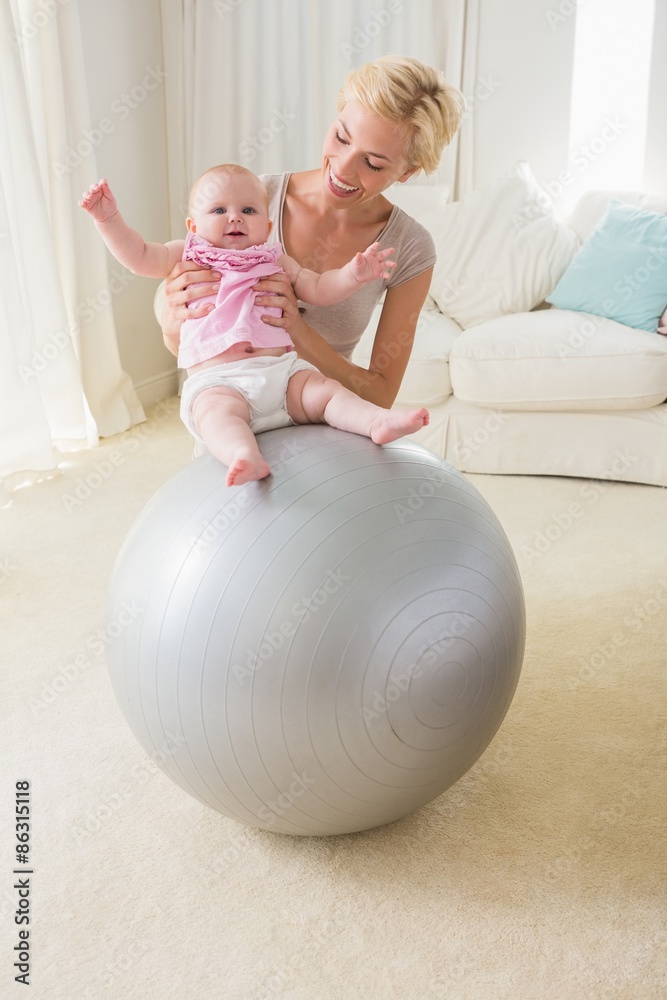 Happy mother with her baby girl in the exercice ball Happy mother with her baby girl in the exercice ball