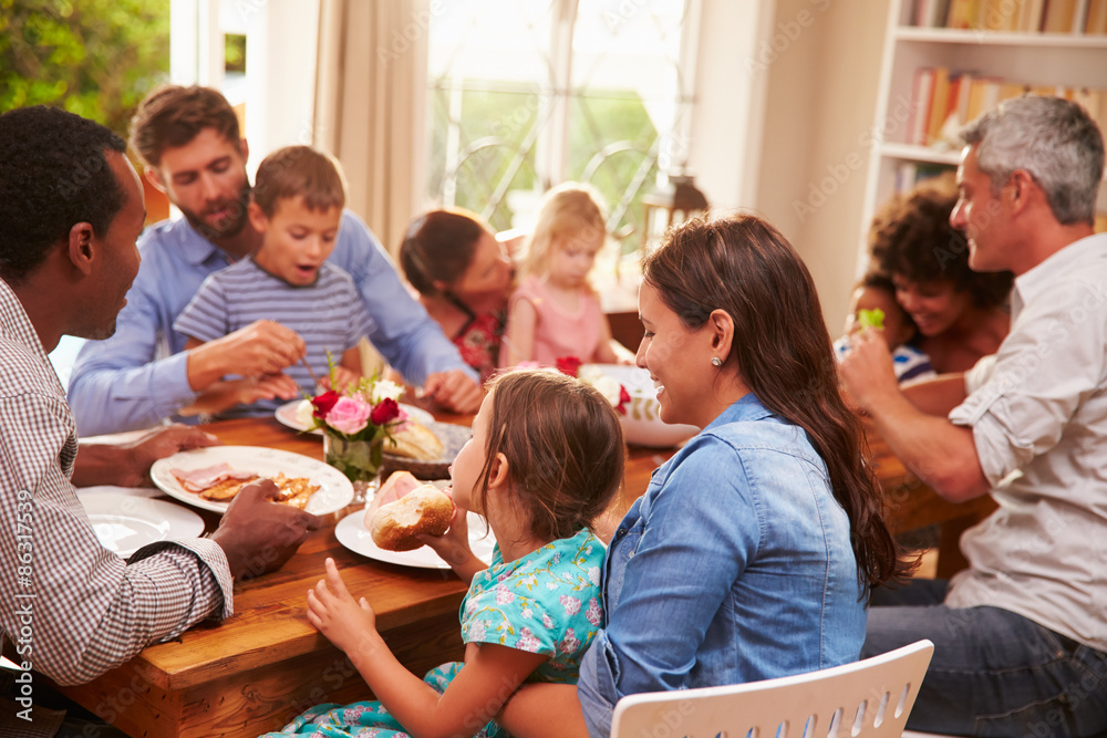 Obraz premium Family and friends sitting at a dining table